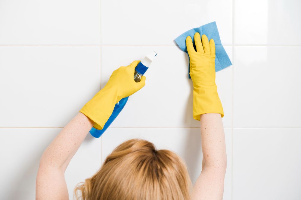 woman-cleaning-shower-wall.jpg