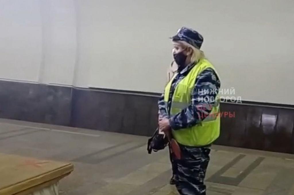 Сотрудница нижегородского метро, которая наблюдает, как полицейские арестовывают молодого человека за отказ надеть маску.